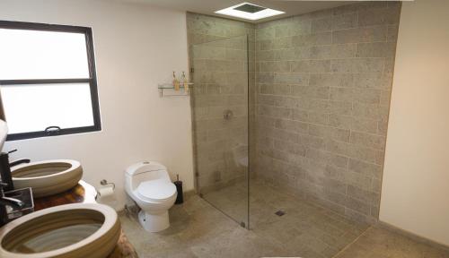a bathroom with a toilet and a glass shower at Estancias Sierravita in Valle de Guadalupe