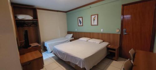 Habitación de hotel con cama y TV en Golden Dolphin Roberto Imóveis, en Caldas Novas