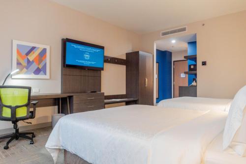 a hotel room with two beds and a flat screen tv at Holiday Inn Express & Suites - Tijuana Otay by IHG in Tijuana