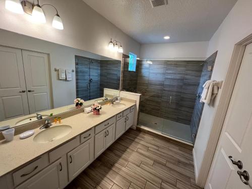 ein Bad mit 2 Waschbecken und einer Dusche in der Unterkunft Brand new home at Sonoma Resort at Tapestry in Kissimmee