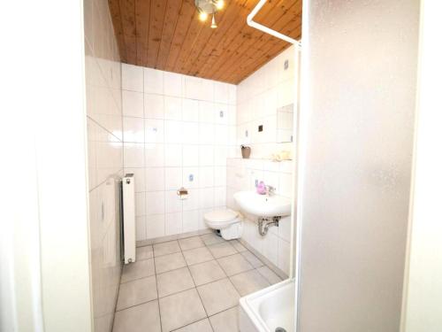 een witte badkamer met een toilet en een wastafel bij Well kept Holiday Home in J chen on Paardenboerderij in Jüchen
