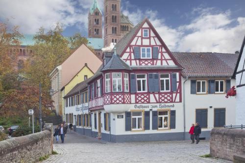 un bâtiment avec des ornements rouges et blancs dans une rue dans l'établissement Gasthaus zum Halbmond, à Speyer