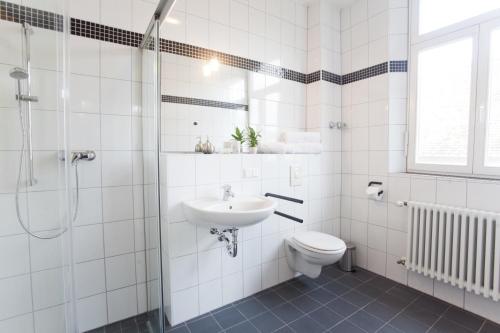 y baño con lavabo, aseo y ducha. en Gasthaus zum Halbmond, en Speyer