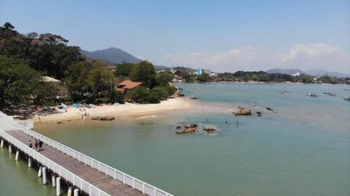 a bridge over a beach next to a body of water at Pousada Villa Vantino in Penha