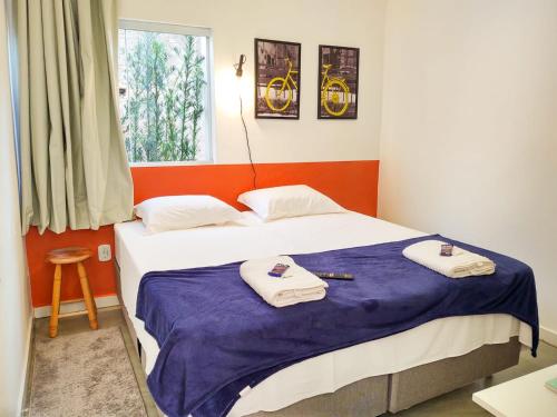 a bedroom with a bed with towels on it at Casas no centro com o sossego da roça - Hospedado por Casa de Tijolinho in Cunha