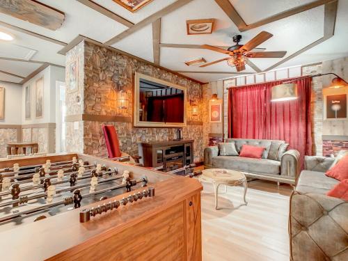 a living room with a game table and a couch at Marvelous Magical House: Amazing Themes and Pool, 5mi Disney in Kissimmee