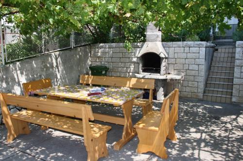 a picnic table and benches with a pizza oven at Apartments by the sea Dramalj, Crikvenica - 5596 in Dramalj