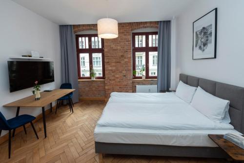 a bedroom with a large bed and a table and chairs at PROVENIR HOME KWIATOWA 5 in Poznań
