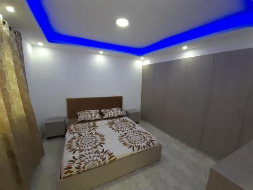 - une chambre avec un lit et un plafond bleu dans l'établissement Dar salah, à Hammamet