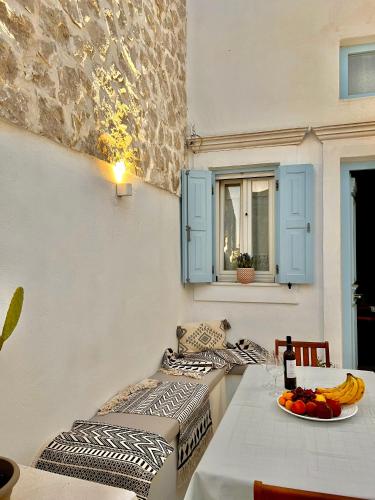 a table with a plate of fruit and a window at Aetheria traditional house in Koskinou