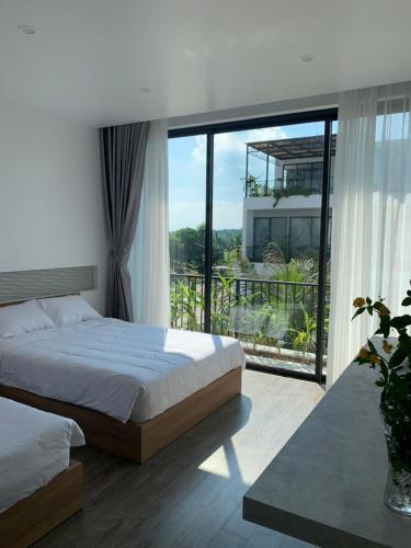 a bedroom with a bed and a large window at Joy Villa Đại Lải - 5 phòng ngủ in Phúc Yên