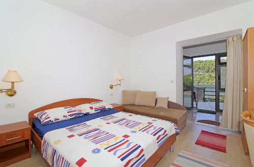 ein Schlafzimmer mit einem Bett und einem Sofa in der Unterkunft Apartments by the sea Polace, Mljet - 613 in Polače
