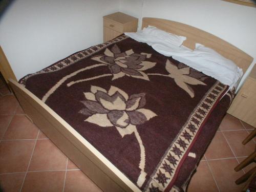 a bed with a brown blanket with flowers on it at Apartments by the sea Pomena, Mljet - 614 in Pomena