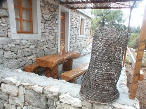 a stone building with a bench and a vase at Apartments by the sea Pomena, Mljet - 614 in Pomena