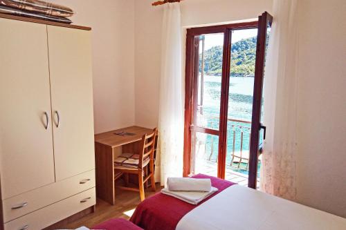 1 dormitorio con cama, ventana y escritorio en Apartments by the sea Prozurska Luka, Mljet - 618, en Okuklje