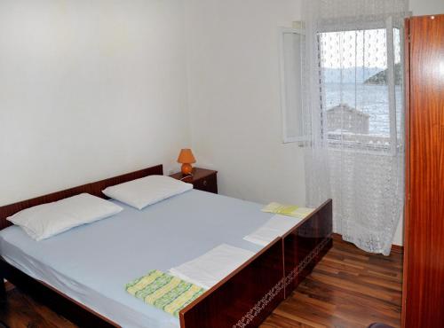 a bedroom with a large bed and a window at Apartments by the sea Prozurska Luka, Mljet - 619 in Prožura