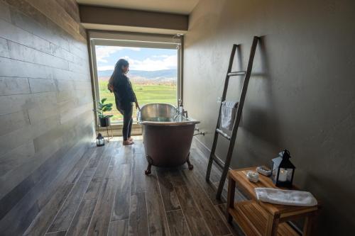 a man standing in a bathroom with a tub in a window at Red Sands Hotel in Torrey