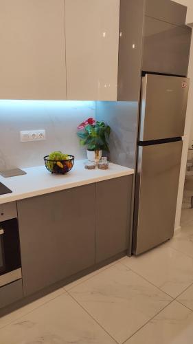 a kitchen with a refrigerator and a bowl of vegetables at Apartments Barbie in Rethymno Town