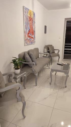 a living room with couches and tables and a painting at Apartments Barbie in Rethymno Town