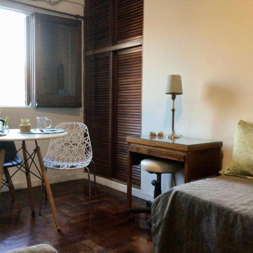 Zimmer mit einem Schreibtisch, einem Tisch und einem Bett in der Unterkunft Casa Salta in Corrientes