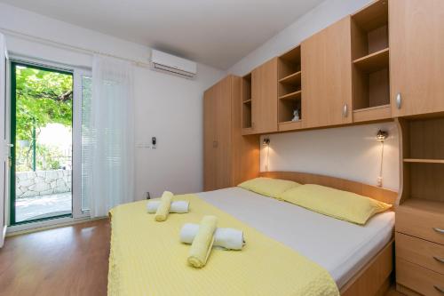 a bedroom with two beds with yellow sheets and a window at Apartments with a parking space Brela, Makarska - 6907 in Brela