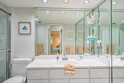 a bathroom with a sink and a toilet and a mirror at Luxury Sanibel Condo with Ocean View Steps to Beach in Sanibel