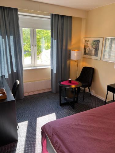 a hotel room with a bed and a table and a window at Noah Longstay in Västerås