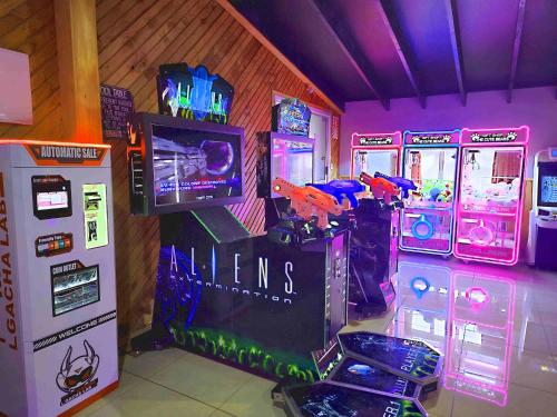 una sala con juegos de arcade y un sistema de videojuegos en Pipers Lodge, en National Park