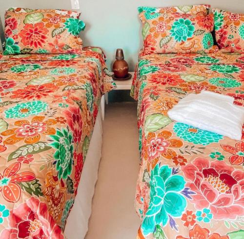 two beds sitting next to each other in a bedroom at Vila Avian Preá in Prea