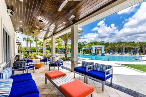 a patio with blue chairs and a swimming pool at 3830 Premier Villa 6Bd Private Pool and Game Room in Kissimmee