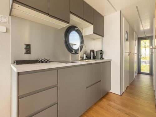 uma cozinha com um lavatório e um espelho em Comfortable houseboat in Marina Volendam em Volendam