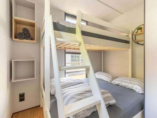 a small bedroom with bunk beds and a bed at Comfortable houseboat in Marina Volendam in Volendam