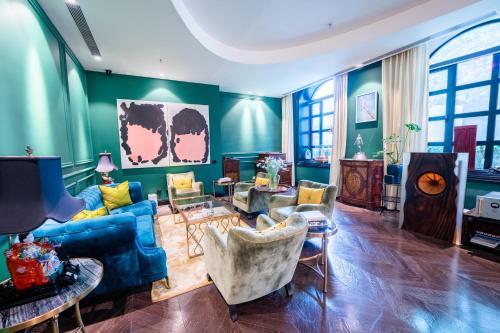 a living room with a blue couch and chairs at Gracie Art Hotel in Beijing