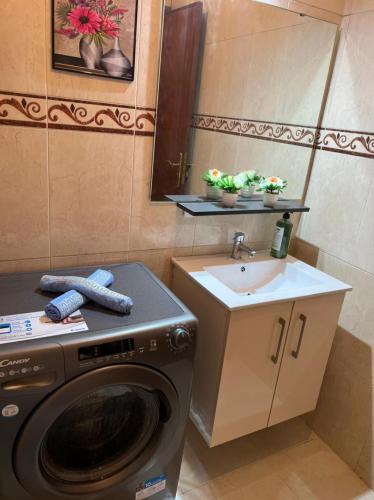 Un baño con lavadora y lavabo. en Magnifique appartement proche Arribat Center, en Rabat