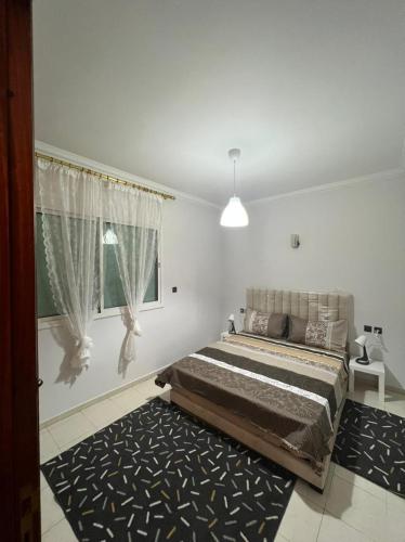 - une chambre avec un lit, une fenêtre et un tapis dans l'établissement Magnifique appartement proche Arribat Center, à Rabat
