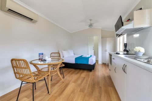 um quarto com uma cama, uma mesa e cadeiras em Darwin FreeSpirit Resort em Darwin