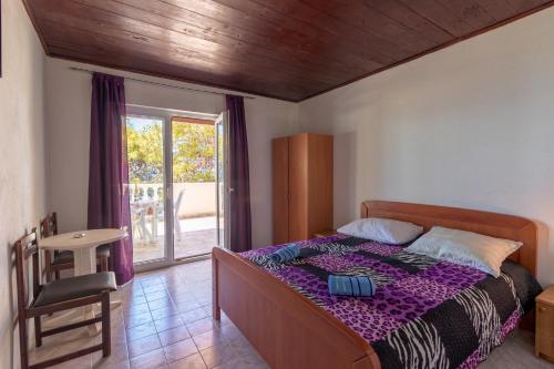 een slaapkamer met een bed, een tafel en een raam bij Seaside secluded apartments Cove Torac, Hvar - 575 in Gdinj
