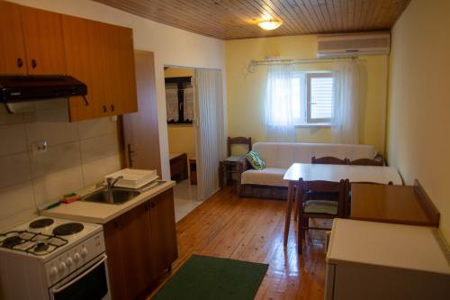 a kitchen and living room with a stove and a table at Apartments by the sea Viganj, Peljesac - 633 in Viganj