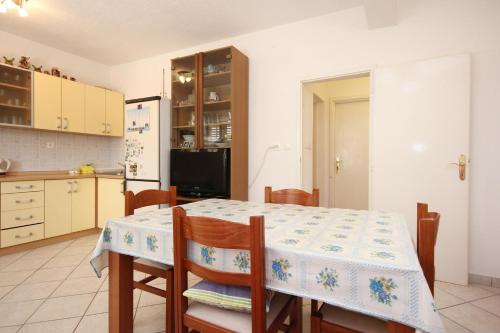 een keuken met een tafel, stoelen en een koelkast bij Apartments by the sea Viganj, Peljesac - 633 in Viganj