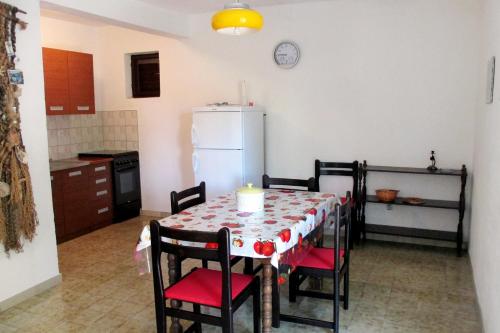 uma cozinha com uma mesa com cadeiras e um frigorífico em Apartments by the sea Mudri Dolac, Hvar - 582 em Vrboska