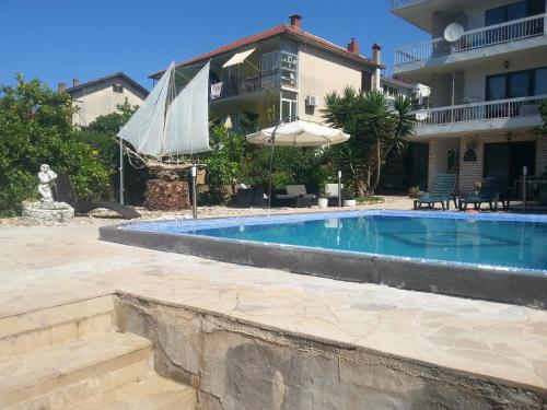una piscina con sombrilla junto a una casa en Family friendly apartments with a swimming pool Stari Grad, Hvar - 583 en Stari Grad