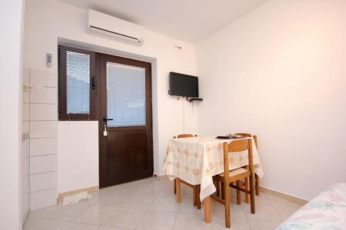 Habitación con mesa, sillas y puerta en Family friendly apartments with a swimming pool Stari Grad, Hvar - 583 en Stari Grad