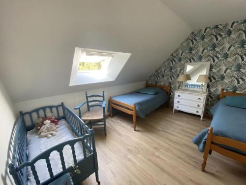 - une chambre mansardée avec 2 lits et une fenêtre dans l'établissement Maison Authentique avec Parc, Cheminée et Équipements Modernes au Cœur de la Vallée de la Loire - FR-1-381-468, à Souvigny-de-Touraine
