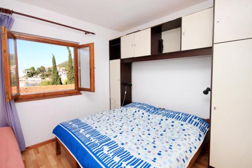 a bedroom with a bed and a window at Apartments by the sea Brna, Korcula - 560 in Smokvica