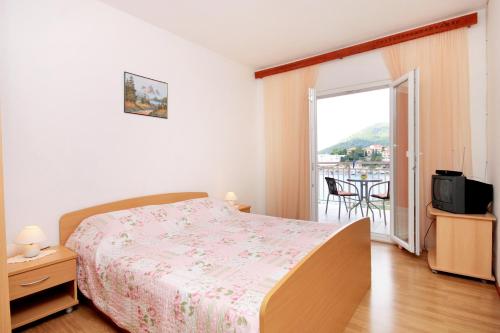 a bedroom with a bed and a balcony at Apartments by the sea Brna, Korcula - 574 in Smokvica