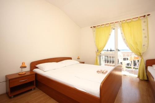 1 dormitorio con 1 cama y ventana con balcón en Apartments with a parking space Orebic, Peljesac - 638, en Orebić