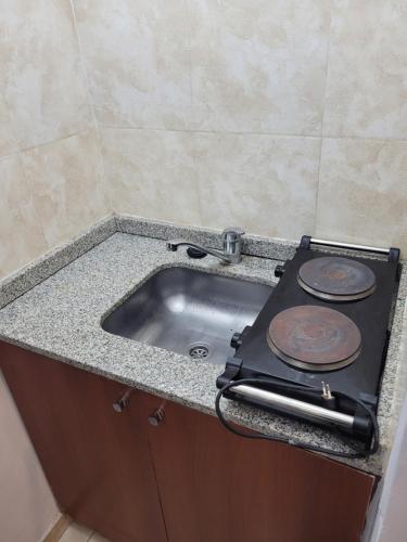 a kitchen counter with a stove and a sink at Departamento Calle San Martin ( Microcentro) in San Miguel de Tucumán