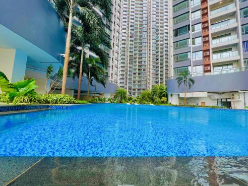 a large blue swimming pool with tall buildings at R&F PRINCESS COVE BY HOMEFORT SUITES in Johor Bahru