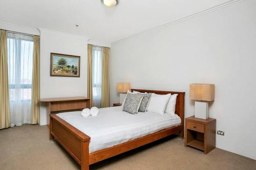 Un dormitorio con una cama con dos velas. en ALF49-Huge 2BR Penthouse Style, Great Water Views en Sídney