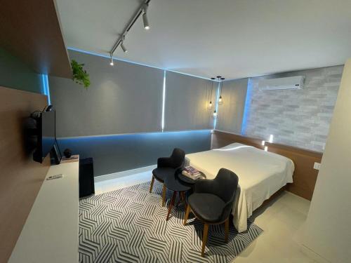 una camera con due sedie e un letto e un tappeto di Apartamento temático luxo Mundo do Vinho! a Bento Gonçalves